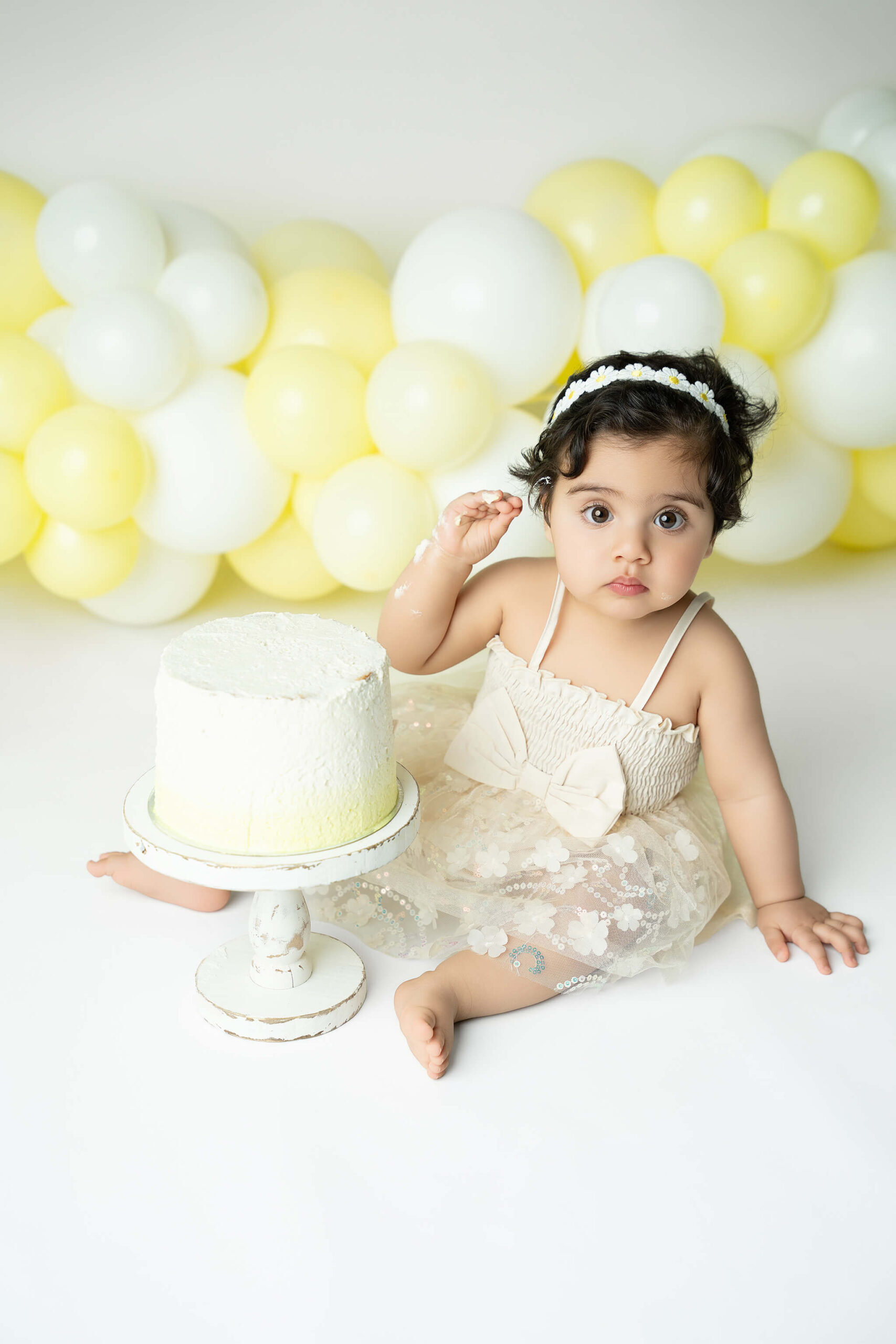 Smash the cake fotografering Stockholm – liten flicka med gul och vit tårta