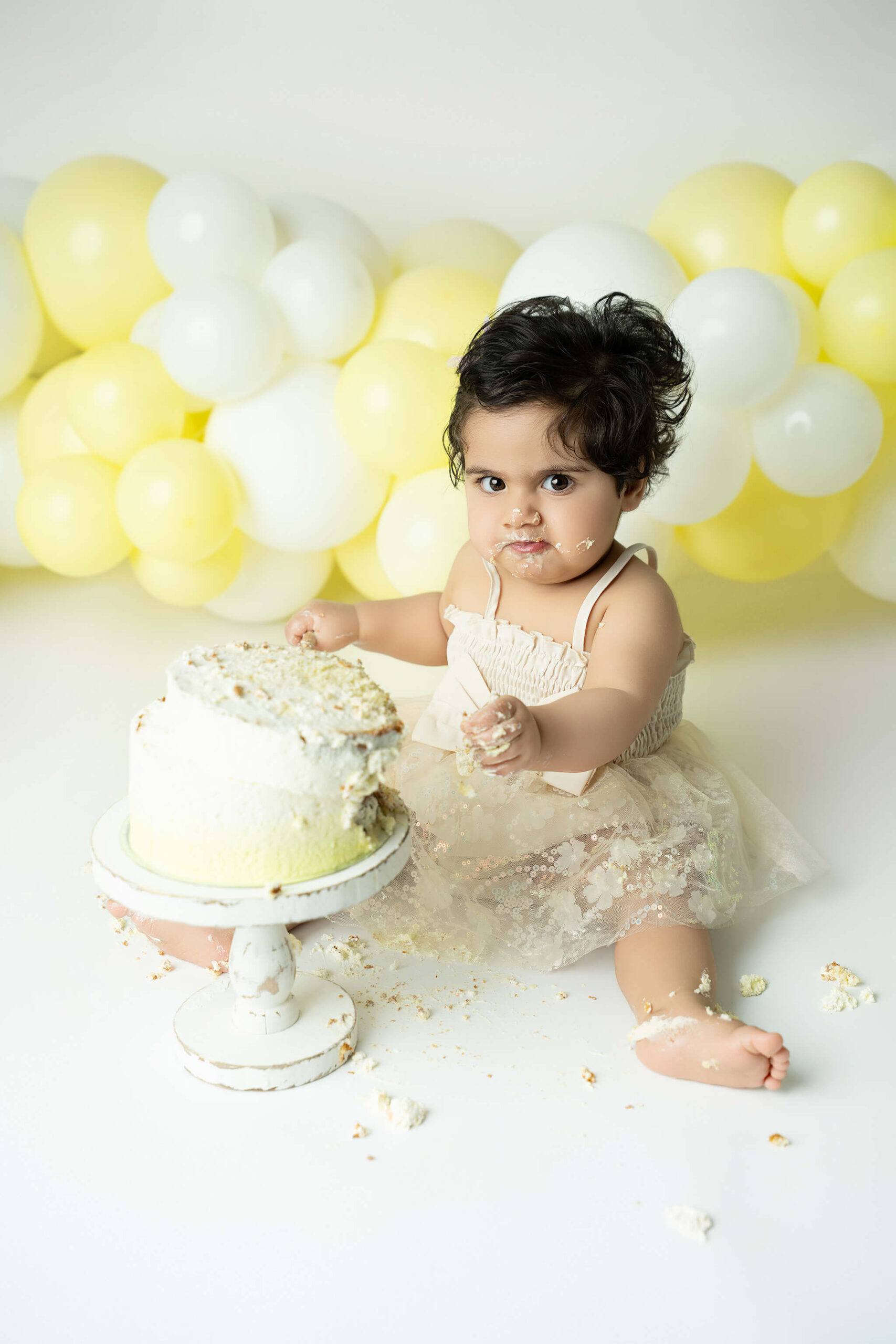 Smash the cake fotografering Stockholm – liten flicka med gul och vit tårta