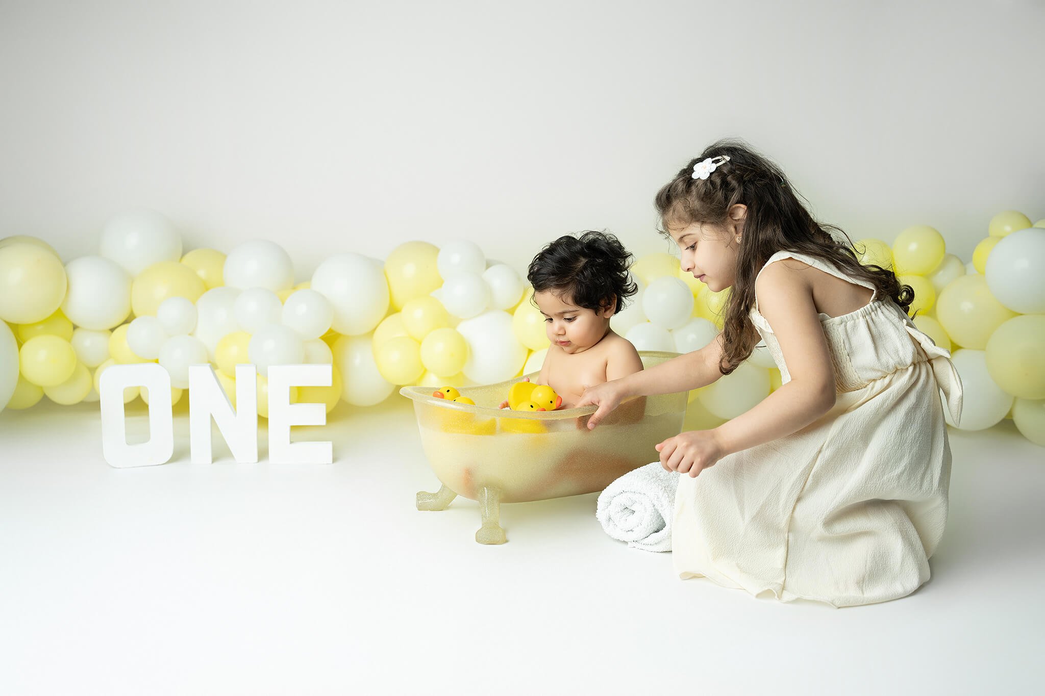 Smash the cake fotografering Stockholm – liten flicka med gul och vit tårta