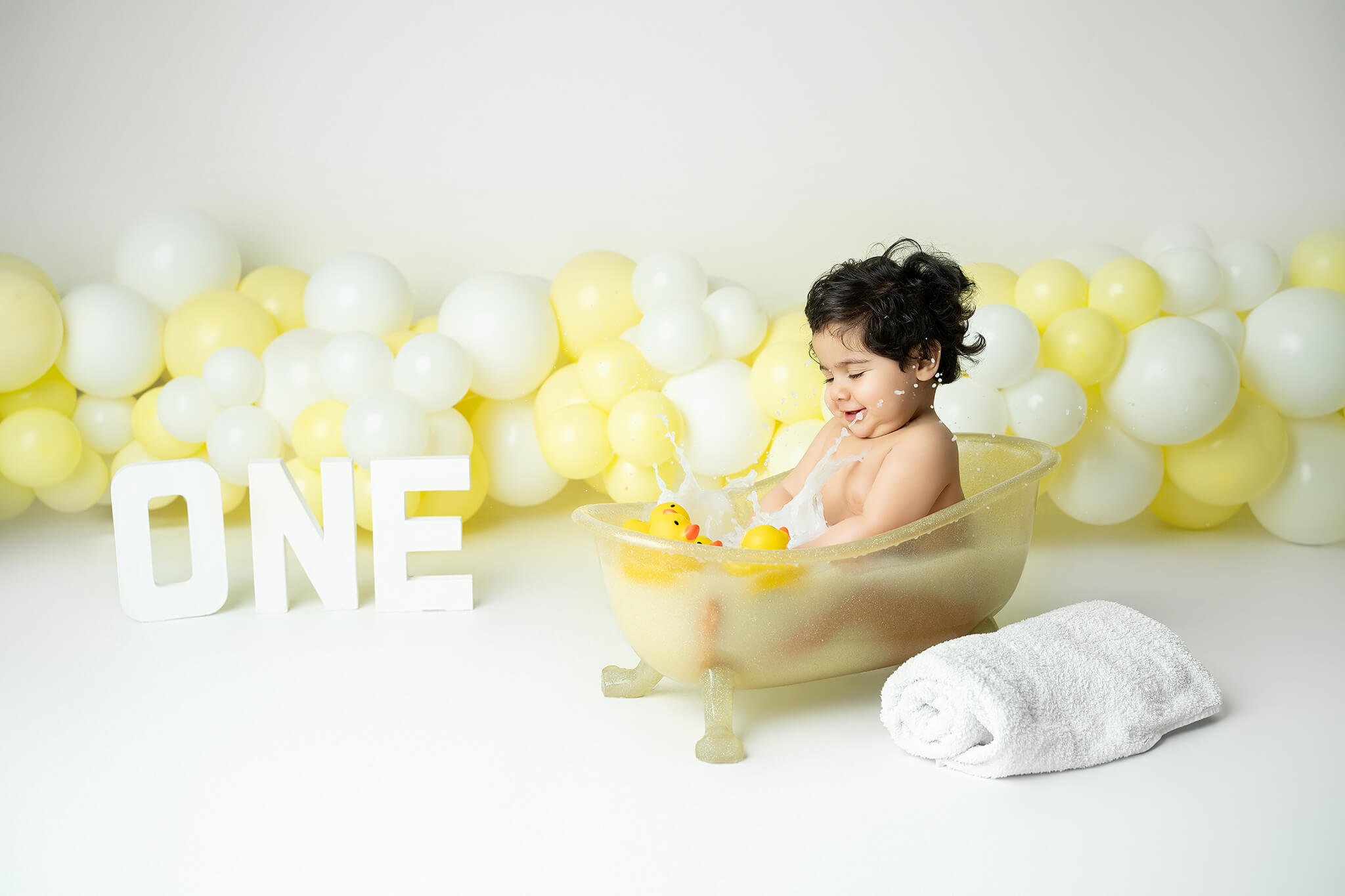 Smash the cake fotografering Stockholm – liten flicka med gul och vit tårta